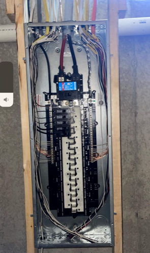 Open electrical breaker panel with exposed wiring and multiple circuit breakers mounted inside a wall cavity